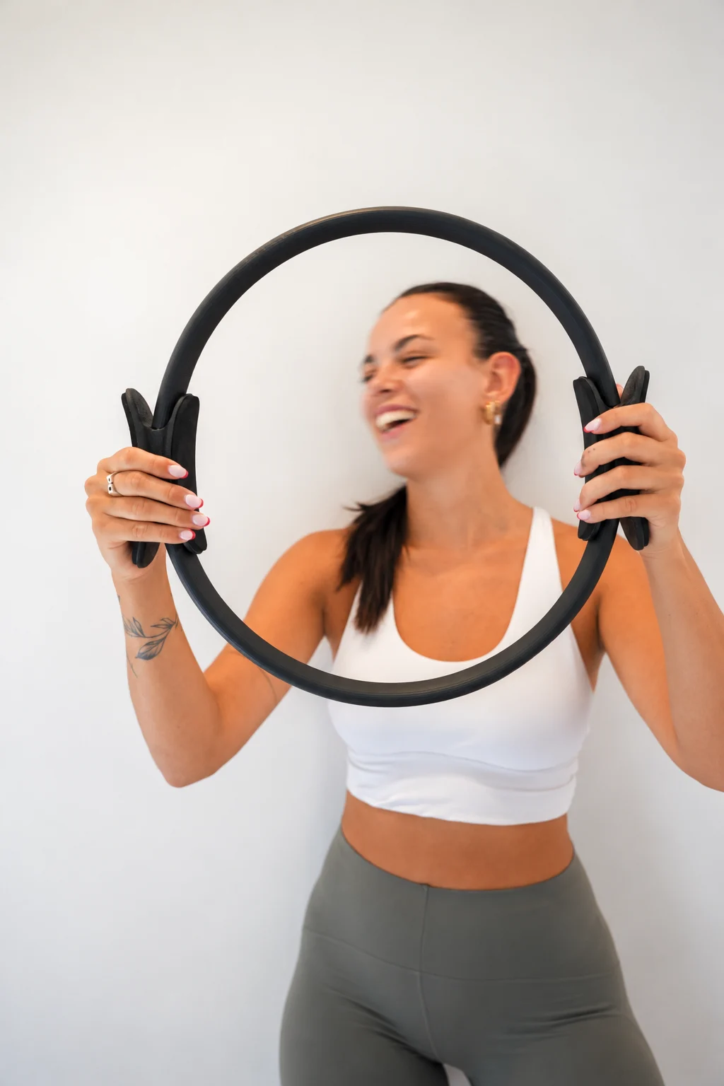 Smiling participant holding a Pilates ring during class